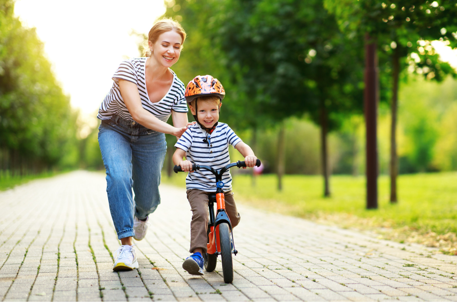 dziecko-jedzie-na-rowerku-dzieciecy-biegowym-w-parku-w-asyscie-swojej-mamy-1
